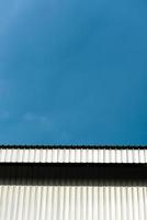 Grey and white building facade and blue sky. photo