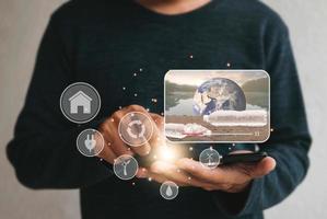 man using cellphone for watching video on internet about energy sources environmen.  Renewable green energy eco saving technology and global warming concept. Elements of this image furnished by NASA photo