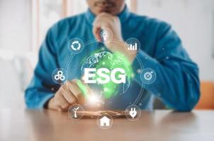 Businessman use phone for analyze Environmental technology and approaching global sustainable ESG by clean energy and power . ESG environmental social governance business strategy investing concept. photo