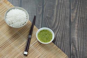 rice and chopsticks on wood table photo