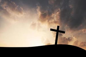 The cross on mountain sunset background photo