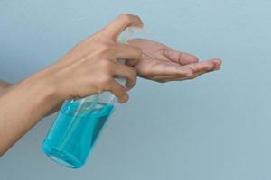mujer sosteniendo gel de alcohol en la mano para lavar prevenir virus y bacterias foto