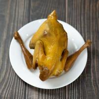 Roasted chicken with a golden crust  on a woodle table photo