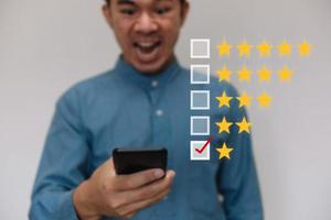 Businessmen wearing a light blue shirt to selecting the level of satisfaction score icons with copy space. Customer service experience and business satisfaction survey concept photo