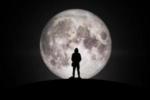 Silhouette of man  Looking at the moon with hope Fulfillment in love. Elements of this image furnished by NASA. photo