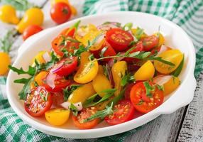 Salad of fresh cherry tomatoes with onion and arugula photo