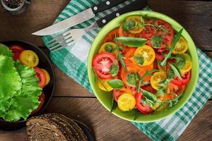 Summer tomato salad with basil, pesto and arugula photo