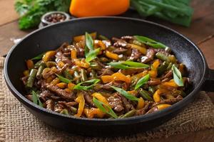 Stir frying beef with sweet peppers and green beans photo