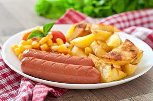 Sausage with fried potatoes and vegetables  on a plate photo