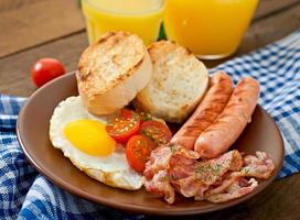 English breakfast - toast, egg, bacon and vegetables in a rustic style on wooden background photo