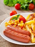 Sausage with fried potatoes and vegetables  on a plate photo