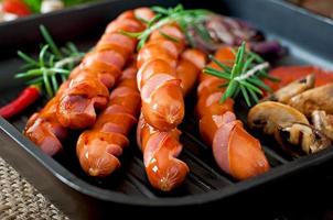 Fried sausages with vegetables on a white plate photo