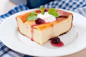 Appetizing cottage cheese casserole on white plate close up photo