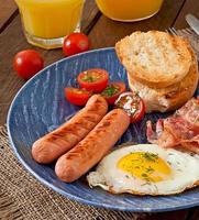 English breakfast - toast, egg, bacon and vegetables in a rustic style on wooden background photo