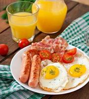 English breakfast - toast, egg, bacon and vegetables in a rustic style on wooden background photo