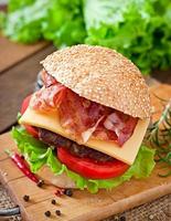 Big sandwich - hamburger burger with beef, cheese, tomato and fried bacon photo