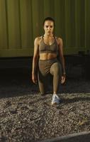 Young woman in sportswear exercising at urban environment photo