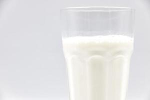 Milk in glass closeup on a white background. photo