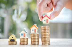 Hand of boy holding home or house on gold coins stack to saving money invest for future and buy home.Concept loan, property ladder, financial, real estate investment and bonus. photo