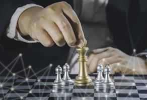 Hand of businessman holding gold king chess on stock market or forex trading graph chart with cityscape image economy trend for digital financial investment.Management or leadership strategy concept. photo