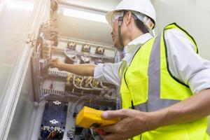 ingeniero masculino revisando el sistema eléctrico con equipo electrónico foto