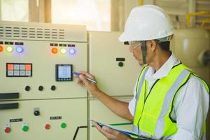 Electrical engineers test the voltage and current of the wires in the electrical cabinet control.the multimeter is in the hands of the electrician details. photo