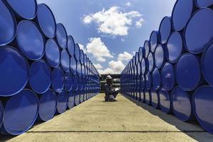 Male worker inspection drum oil stock barrels blue photo