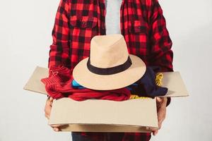 man holding a crate of second-hand clothes unused clothes photo