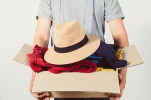 man holding a crate of second-hand clothes unused clothes photo