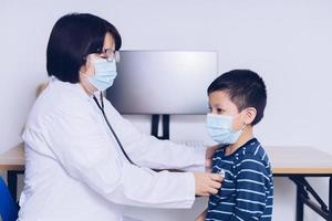 The doctor sits at work, examining a child patient. photo