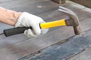 A builder drives nails into the board. photo