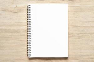 Blank spiral bound notepad mockup template with Kraft Paper cover, isolated on wood background. photo