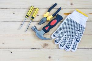 guantes y herramientas sobre fondo de madera foto