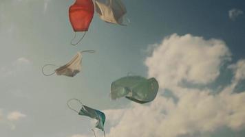 werpt medische beschermende maskers op in de blauwe lucht. herstel of vrij van het concept van de coronavirusziekte. video