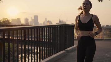 joven atleta corriendo descansando exhausta después de un ejercicio de entrenamiento cardiovascular en la puesta de sol de la ciudad urbana. jogging estilo de vida saludable. video