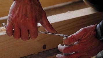 Hands of master twist washer with nut onto a threaded steel stud into concrete floor of rough floor for installation of wooden floor log. Repair and construction with your own hands - DIY. Slow motion video