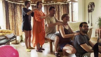 i membri della famiglia, a turno, si massaggiano le spalle nel soggiorno di casa. video