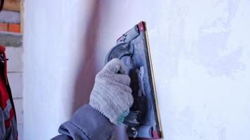 Sanding of walls with sandpaper after treatment with dry building mixes with plaster and putty before painting. The surface alignment is smooth. Home renovation with your own hands video