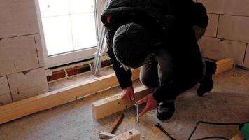 Hands of master twist washer with nut onto a threaded steel stud into concrete floor of rough floor for installation of wooden floor log. Repair and construction with your own hands - DIY. Slow motion video