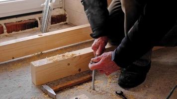 Hands of master twist washer with nut onto a threaded steel stud into concrete floor of rough floor for installation of wooden floor log. Repair and construction with your own hands - DIY. Slow motion video