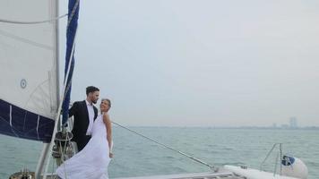 casal romântico velejando, casais estão felizes em comemorar em um veleiro, aproveitando o conceito de amor de veleiro lindo dia video