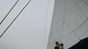 casal romântico velejando, casais estão felizes em comemorar em um veleiro, aproveitando o conceito de amor de veleiro lindo dia video