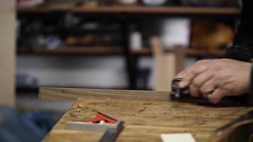 carpintero en el taller hace muebles con una herramienta de mano video