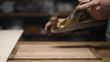 a carpenter using a hand planer levels the surface of a walnut wood blank video