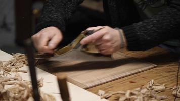 a carpenter using a hand planer levels the surface of a walnut wood blank video