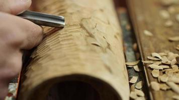 carver cuts wooden detail on woodworking chisel video