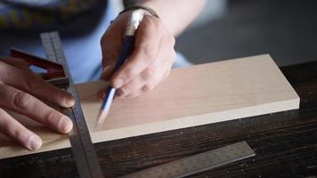 Travailleur du bois marque le détail du bois avec un carré et un crayon video