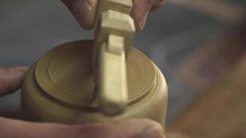 a potter cuts a circle of clay with a compass video