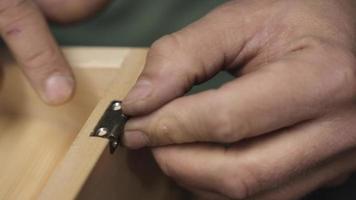 carpenter embeds a hinge in furniture video