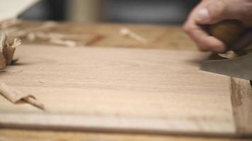 a carpenter using a hand planer levels the surface of a walnut wood blank video